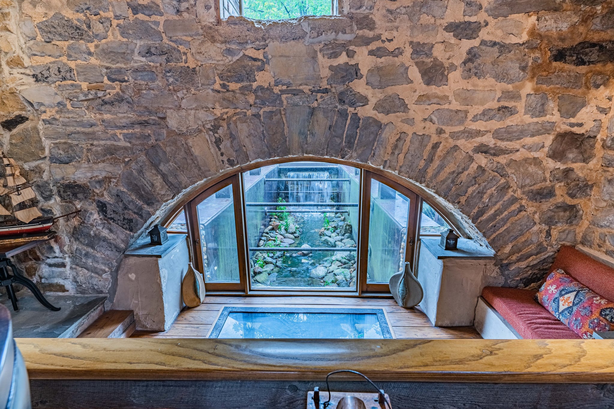 Glass floor panel revealing the millrace flowing directly beneath the house
