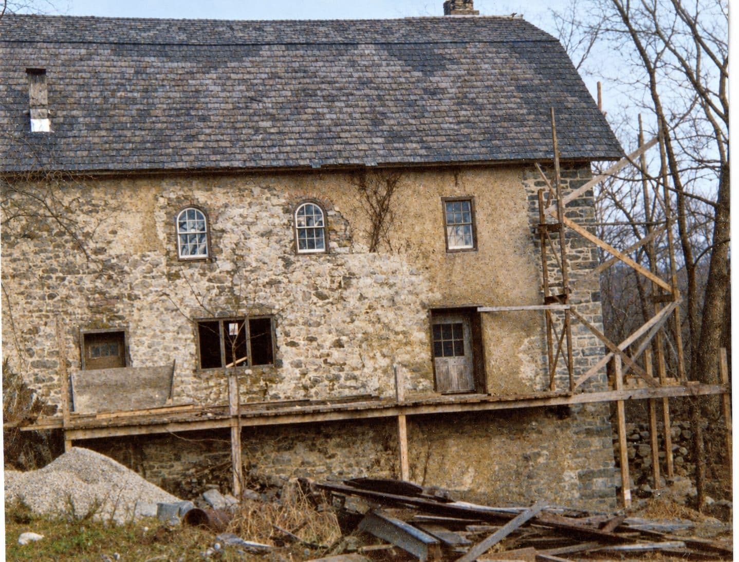 The same exposed stone wall and scaffolding, colour and detail recovered